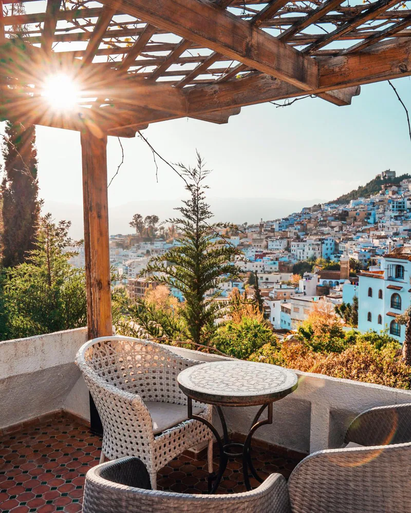 A table for two on a shaded terrace looking over the blue medina